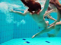 Three nude girls have fun underwater