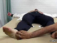 trussed up businessman in a suit tickled all over his soles