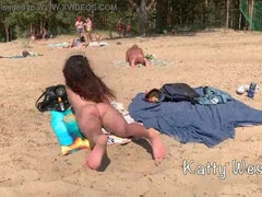Cute girl sunbathes on a nudist beach and pisses in public