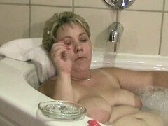 Hot milf enjoys a bath and cigar with large areolas