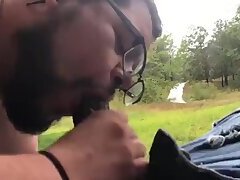 Bearded bear sucks black cock outdoor