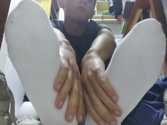 Young guy relaxing his tired feet after a busy day