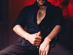 Handsome Noel Dero in a sexy shirt and trousers jerks off with a look at the camera and cums