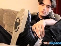 Skinny twink massages his feet and strokes massive dick