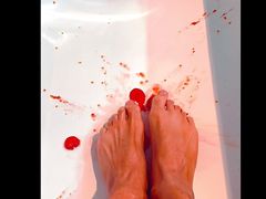 Perfect sexy brown feet squish tomatoes in bathtub