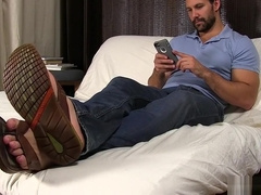 Jet lays on the bed and relaxes his feet after a long day