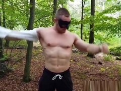 Muscular dude strokes his cock outdoors while wearing a mask