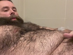 Muscular hairy daddy Teddy Wilder pleasures himself in the bathtub and flaunts his massive testicles