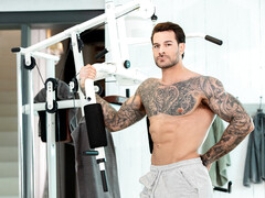 Handsome man with tattoos working out with a hunk