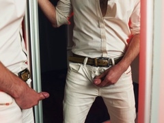 A stunning hunk pleasures himself in front of a mirror, releasing a passionate load that coats the reflective surface.