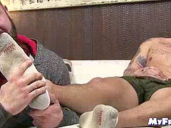 tattooed hunk receives feet tonguing while draining