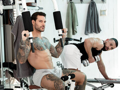 Handsome man with tattoos working out with a hunk