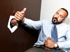 Doominant man plays with a businessman at the glory hole