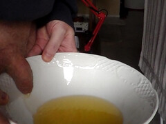 John is pissing in a bowl in closeup