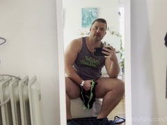 Muscular hairy hunk Koby Falks strokes his massive foreskin-covered dick and cums on a set of briefs