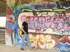 Young guy masturbates in public in front of graffiti wall