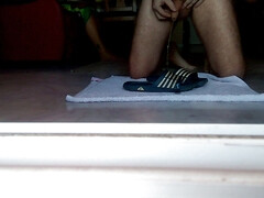 John is peeing on the bathing slippers on the floor